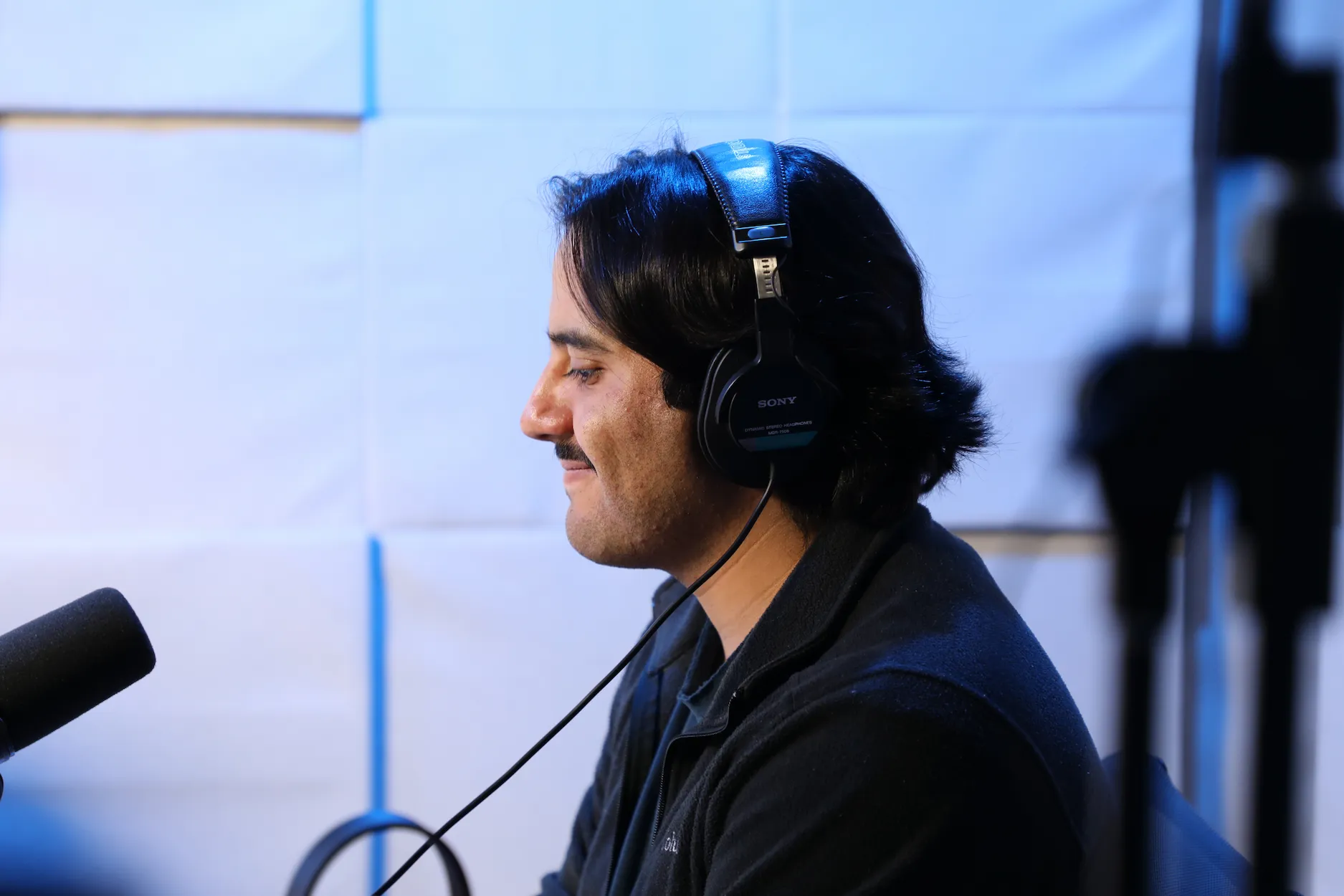 Persona con audífonos grabando un podcast