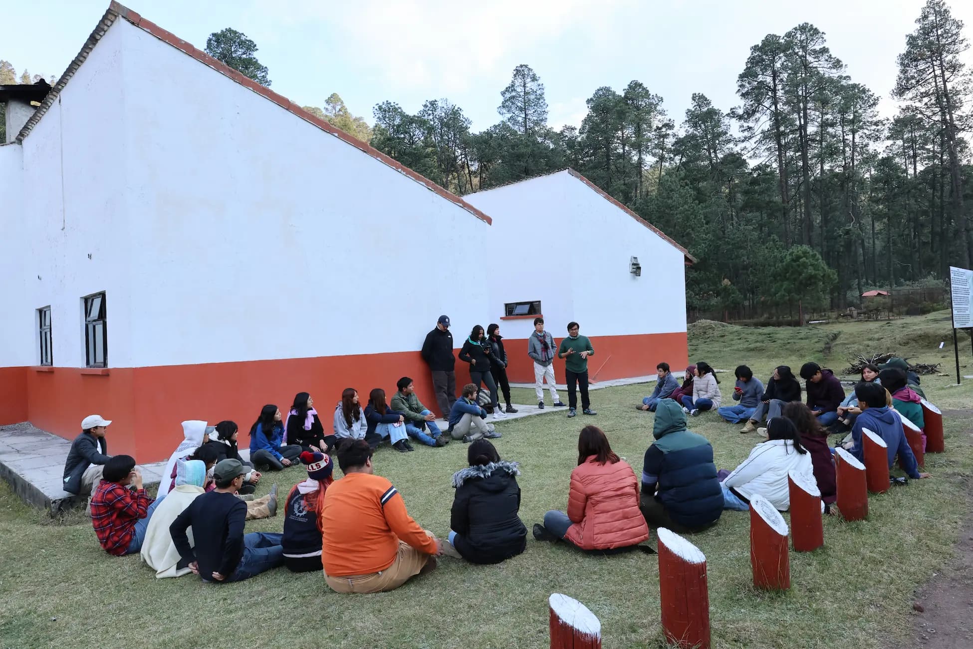 Personas sentadas en círculo en una asamblea al aire libre